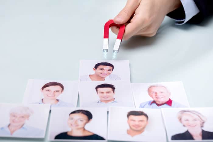 Fotos de pessoas sendo atraídas por um íman, para exemplificar como o marketing atrai um lead. que posteriormente acabará no pré-vendas e para a empresa vender mais.